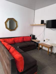 a couch with red pillows in a living room at Marbyn & Ana House in Tegucigalpa
