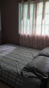 a bed in a bedroom with a window at Marbyn & Ana House in Tegucigalpa