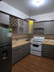 a kitchen with stainless steel appliances and wooden cabinets at Marbyn & Ana House in Tegucigalpa