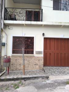 a house with a red door and a balcony at Marbyn & Ana House in Tegucigalpa