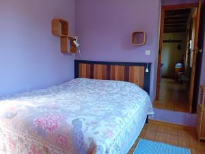 a bedroom with a bed in a room with purple walls at Petite Perle Parinet in La Croisille-sur-Briance