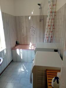 a bathroom with a pink tub and a sink at Petite Perle Parinet in La Croisille-sur-Briance +9 photos