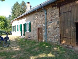 a brick building with a bike parked next to it at Petite Perle Parinet in La Croisille-sur-Briance