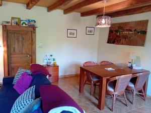 a living room with a blue couch and a wooden table at Petite Perle Parinet in La Croisille-sur-Briance