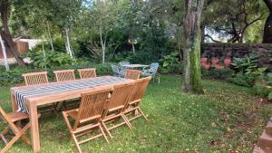 a wooden table with four chairs around it in a yard at A Little Guesthouse in Bloemfontein +11 photos