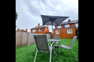a table and chairs with an umbrella in a yard at Peace Guest House in Hoo