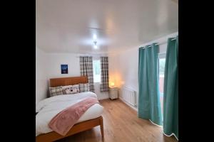 a bedroom with a bed with green curtains in it at Peace Guest House in Hoo