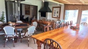 a dining room with a large wooden table and chairs at A Little Guesthouse in Bloemfontein