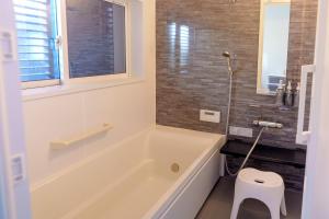 a white bath tub in a bathroom with a stool at Links Seaside resort in Futtsu +14 photos
