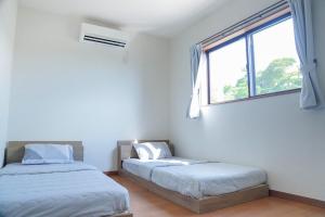 a bedroom with two beds and a window at Links Seaside resort in Futtsu
