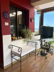 a porch with a bench and a desk with a computer at leiradaporta in Monforte de Lemos