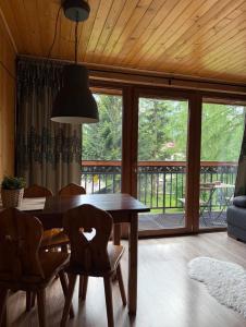 a dining room with a table and chairs and a large window at Willa Karolina Centrum Zakopane in Zakopane