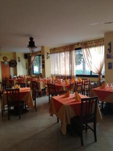 a restaurant with tables and chairs with red table cloth at Hotel La Giara in Zambrone