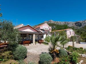 a house with a patio and mountains in the background at Adriatic Guesthouse Balota with Shared Pool in Viganj