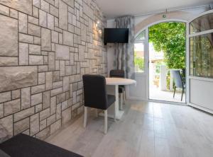 a dining room with a table and a stone wall at Adriatic Guesthouse Balota with Shared Pool in Viganj