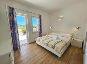 a bedroom with a bed and a large window at Adriatic Guesthouse Balota with Shared Pool in Viganj +78 photos