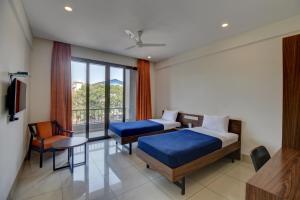 a hotel room with two beds and a window at Hotel Dreamland in Pune