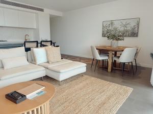 a living room with a couch and a table at Salt & Stone - Harbour Views, Balcony & Parking x1 in Newcastle