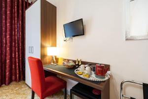 ローマにあるVatican Golden Roomsのテーブルと赤い椅子が備わるホテルルームです。