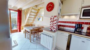 a kitchen with a table and chairs in a kitchen at La Maison du Carbonet in Batz-sur-Mer