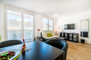 sala de estar con mesa negra y sillas en Duschel Apartments Wien-Hauptbahnhof en Viena