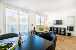 a living room with a black table and chairs at Duschel Apartments Wien-Hauptbahnhof in Vienna