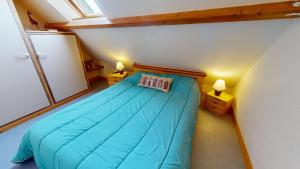 a bedroom with a blue bed in a attic at La Maison du Carbonet in Batz-sur-Mer