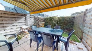 a blue table and chairs on a patio at La Maison du Carbonet in Batz-sur-Mer +12 photos