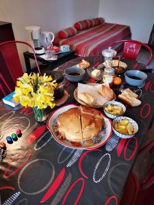 a table with a pie and other food on it at Les racines Bohèmes in Avèze