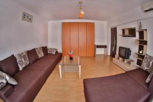 un soggiorno con divano marrone e tavolo di Dream Residence 64 a Bucarest