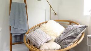 a basket chair with pillows in a room at Stylish Coastal Stay in Cronulla