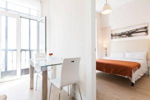 1 dormitorio con cama, mesa y escritorio en Apartamento Trajano, en Sevilla