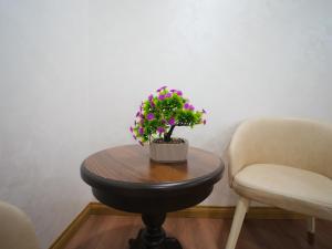 a table with a plant on it next to two chairs at Premiere Hotel Tashkent Pool&Spa in Tashkent