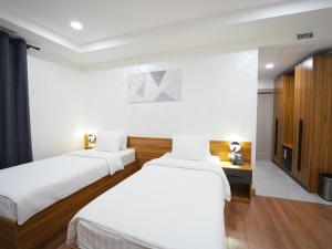 a bedroom with two beds and a television at Premiere Hotel Tashkent Pool&Spa in Tashkent