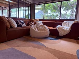 a living room with a brown couch and two chairs at Southern Grampians Lookout in Dunkeld