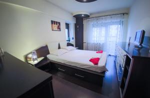 - une chambre avec un lit, un bureau et une télévision dans l'établissement Dream Residence Nerva, à Bucarest