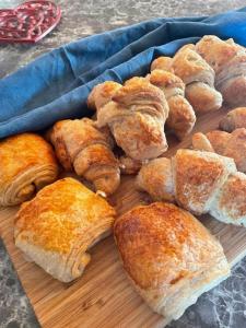 a bunch of pastries on a wooden cutting board at Le Cocon de Tranquillité au Cœur de la Campagne in Les Pégués