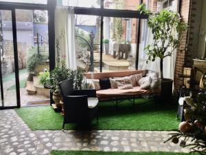 a screened in porch with a couch on the grass at Troglodytes "Loire Sauvage" in Rochecorbon