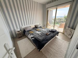 a bedroom with a bed and a balcony at Chambre chez l habitant terrasse vue mer in Sainte-Maxime