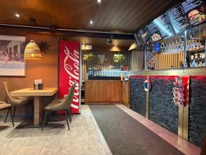 a restaurant with a bar and a table and chairs at Hotel Sommarvind in Inkoo