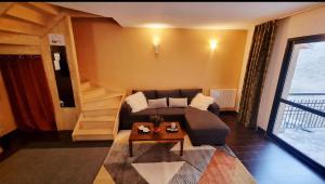 a living room with a couch and a table at Cocon cosy et spa au Château des Magnans Jausiers in Jausiers