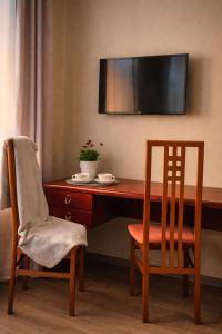 a desk with a chair and a television on a wall at Muzeja apartamenti & Free Parking & Self Check-in in Riga