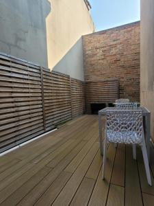 a patio with a table and a chair on a deck at La maison de toujours in La Garenne-Colombes