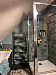a bathroom with a shower and a bath tub at Under The Thatch at Rose House in Iwerne Minster +11 photos