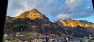 a mountain view of a town and houses in front at La Maison V in Pontebba