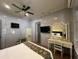 a bedroom with a bed and a desk and a mirror at Hotel Indah Palace Tawangmangu in Tawangmangu