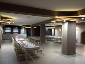 a banquet hall with white tables and chairs at Kék Lagúna Panzió in Dombrád