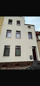 a tall white building with windows on the side of it at Andoniev in Salzelmen