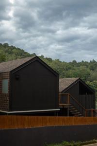 a couple of buildings with trees in the background at BaanTataChiangmai in Ban Pong Khai Tai