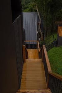 a wooden stairway leading to a yard with a fence at BaanTataChiangmai in Ban Pong Khai Tai